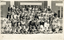 Groupe d'enfants avec leurs accompagnateurs posant devant le bâtiment de la colonie