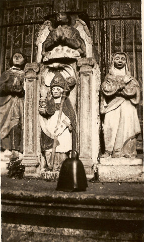 Le groupe sculpté et la cloche dite "Bonnet de saint Mériadec" devant le calvaire bois polychromé du cimetière de stival