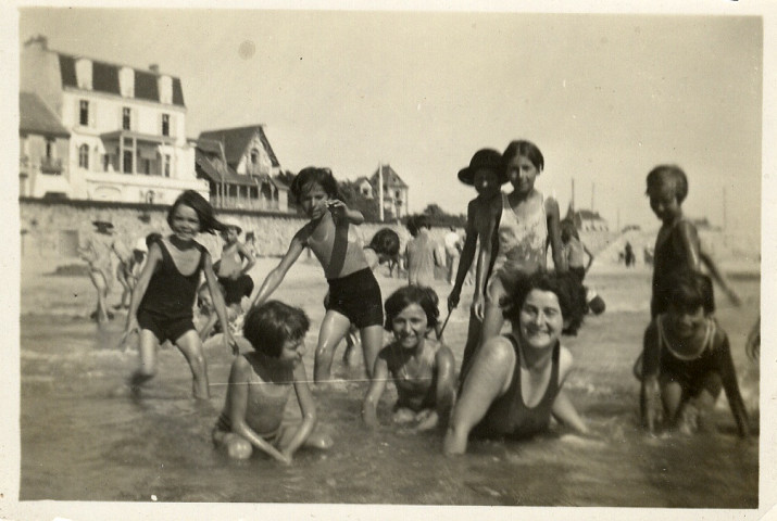 Groupe d'enfants avec leur accompagnatrice jouant dans l'eau