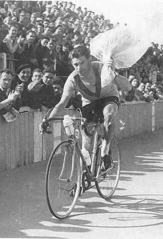 Fernand Picot à vélo un bouquet à la main pendant un tour d'honneur