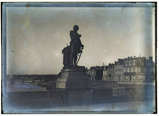 [Statue en pied d'un homme appuyé sur son sabre. La statue est installée sur un pont, en arrière plan, le cours d'eau et la ville] / [cliché de Joseph Bellec].
[ca 1905]