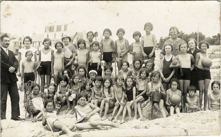 Groupe de fillettes en maillot avec leurs accompagnateurs posant sur la plage. Cliché Nardot, Quiberon