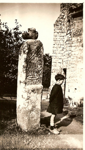 Un enfant (M. Blayo) de profil près du lec'h de Stival, devant l'église Saint-Pierre